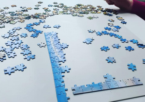 Mieszkanka układająca puzzle na stole