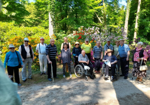 Grupowe zdjęcie mieszkańców na tle zielonej roślinności.