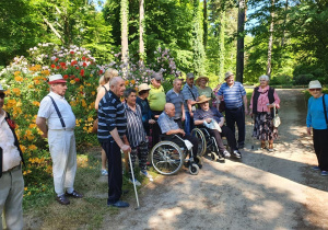 Grupowe zdjęcie mieszkańców na tle zielonej roślinności.