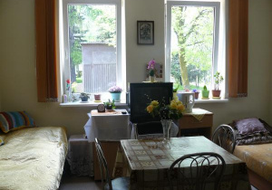 zdjęcie pokoju przedstawiające dwa łózka, stolik i telewizor